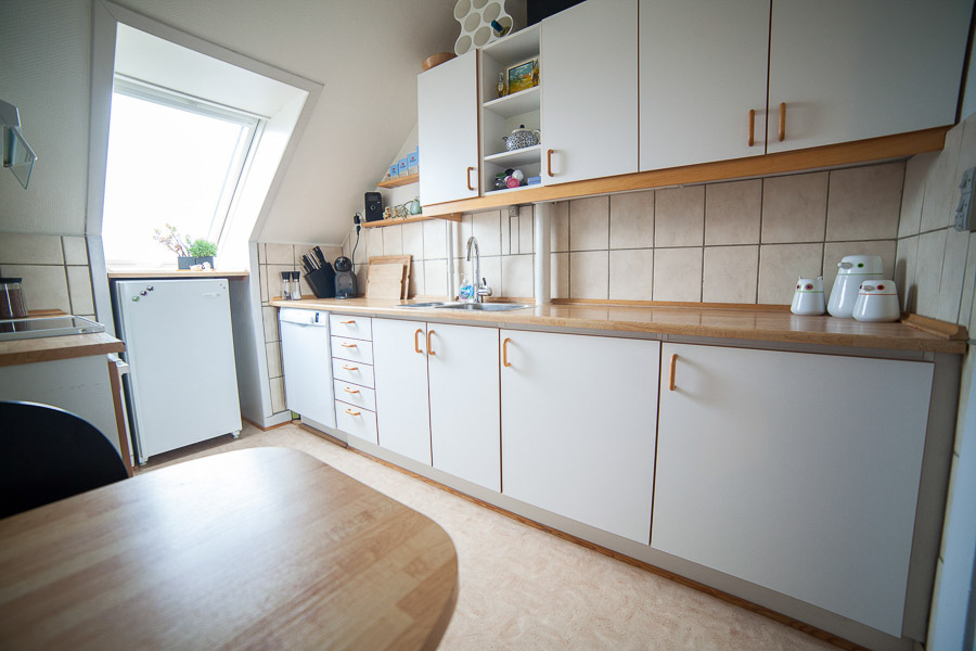 Skråvinduet i enden af køkkenet sender dejligt lys ind. Derudover er der lys under skabene samt en lampe i loftet.