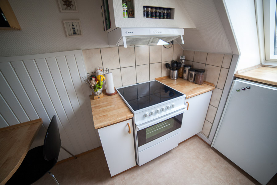 Over komfuret er der hyggelige hylder integreret med skråvæg og emhætte.